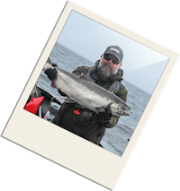 a man holding up a fish on a boat